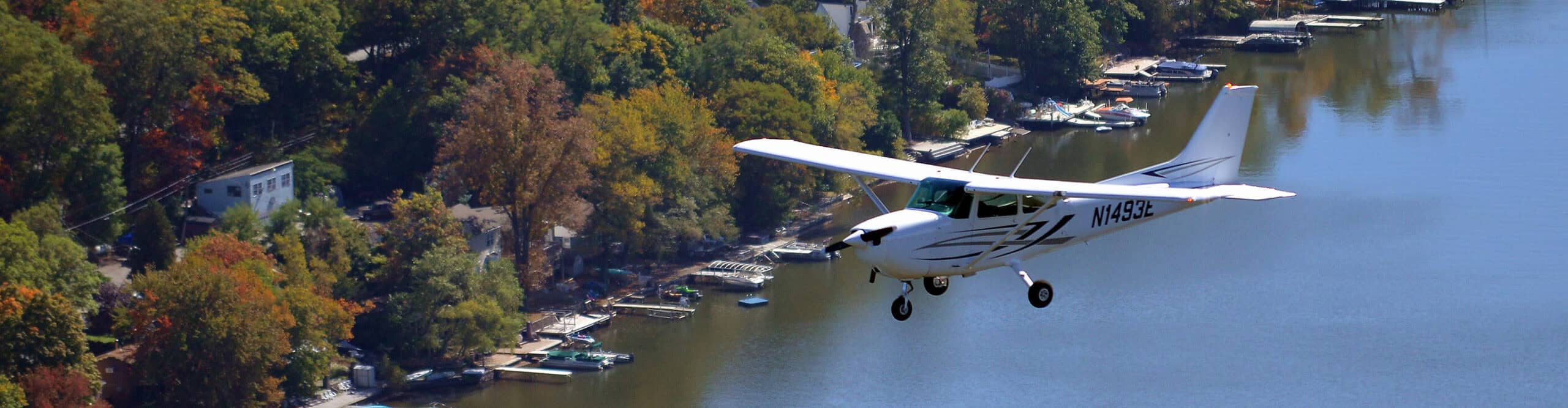 Century Air Cessna flying over lake in Autumn in NJ.